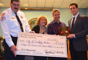Michael and Mia Marie Shaluly presented a check to city officials for the city's 9/11 memorial.