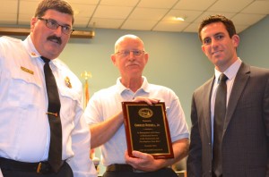 Safety Harbor Fire Chief Joe Accetta (L) and Mayor Joe Ayoub present Charles Russell, Jr. with his awards.