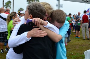 Mindy Crawford is embraced by her son and sister after completing the Best Damn Race 5k.