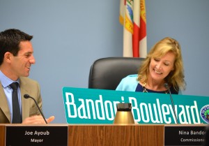 Joe Ayoub presents a street sign to departing Commissioner Nina Bandoni.
