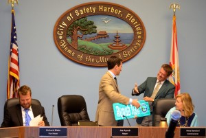 Commissioner Cliff Merz presents Joe Ayoub with a street sign.