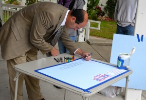 Mayor-elect Andy Steingold signs a memory board for one of the crash victims. 