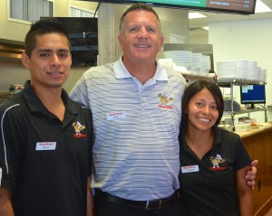 Burger Monger founder Jake Hickton poses with two of his employees.