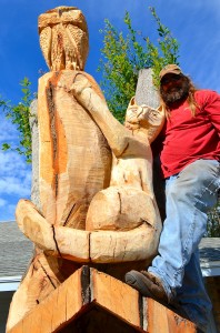 Woodcarver Warren Hunt poses with his "living" sculpture on Enterprise Road.