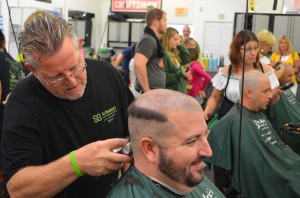 Chop Shop owner Mike Platow performs a head shave at the salon's 2014 St. Baldrick's Foundation fundraiser.