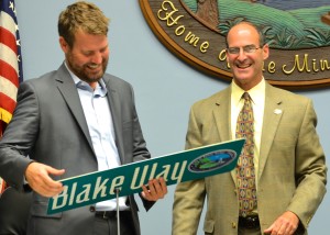 Mayor Andy steingold presents a street sign to Rick Blake.