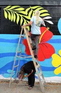 Local artists Todd Ramquist and Kiaralinda paint a mural on the wall at Cox Cleaners in safety Harbor.